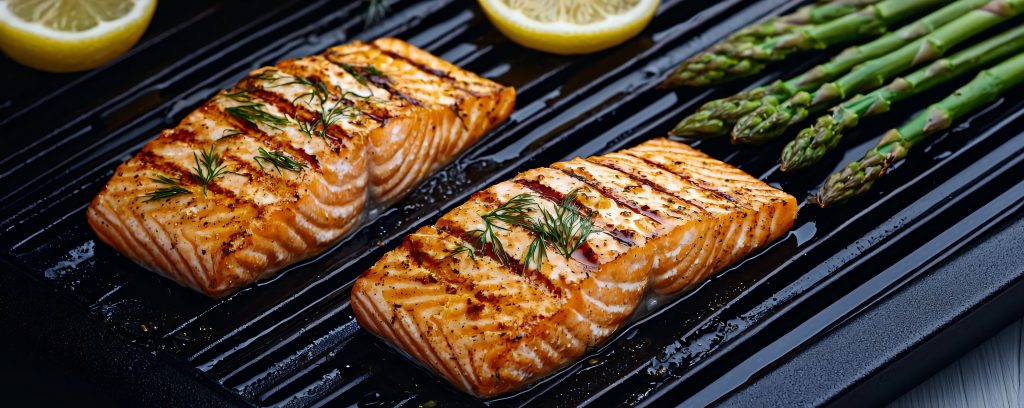 Delicious grilled salmon fillets served with fresh asparagus and lemon slices, perfect for healthy meal inspiration.