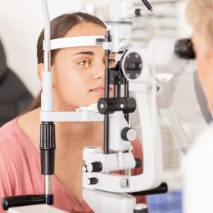 Eye, optometrist and eye exam in ophthalmologist office with optical machine to examine vision weak iris, pupil or lens of eyeball. Woman, optical clinic test and professional optician eye care test