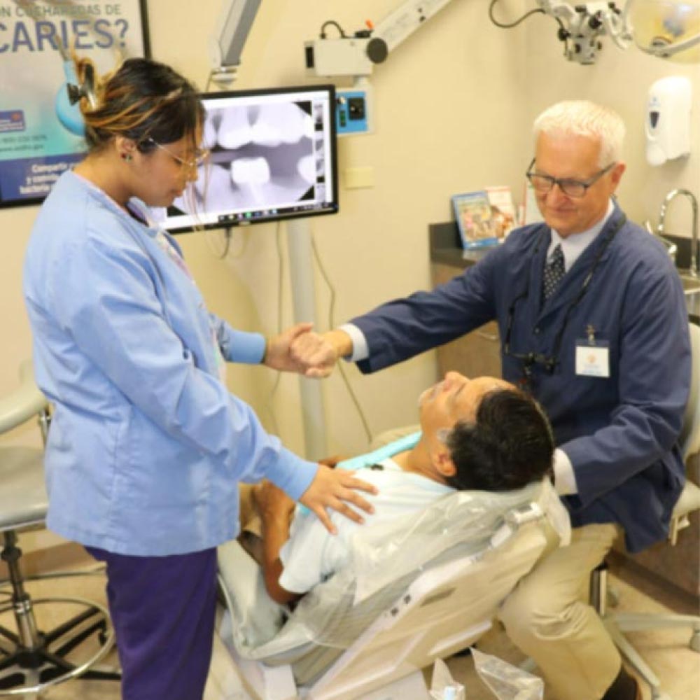 Dentist praying over patient
