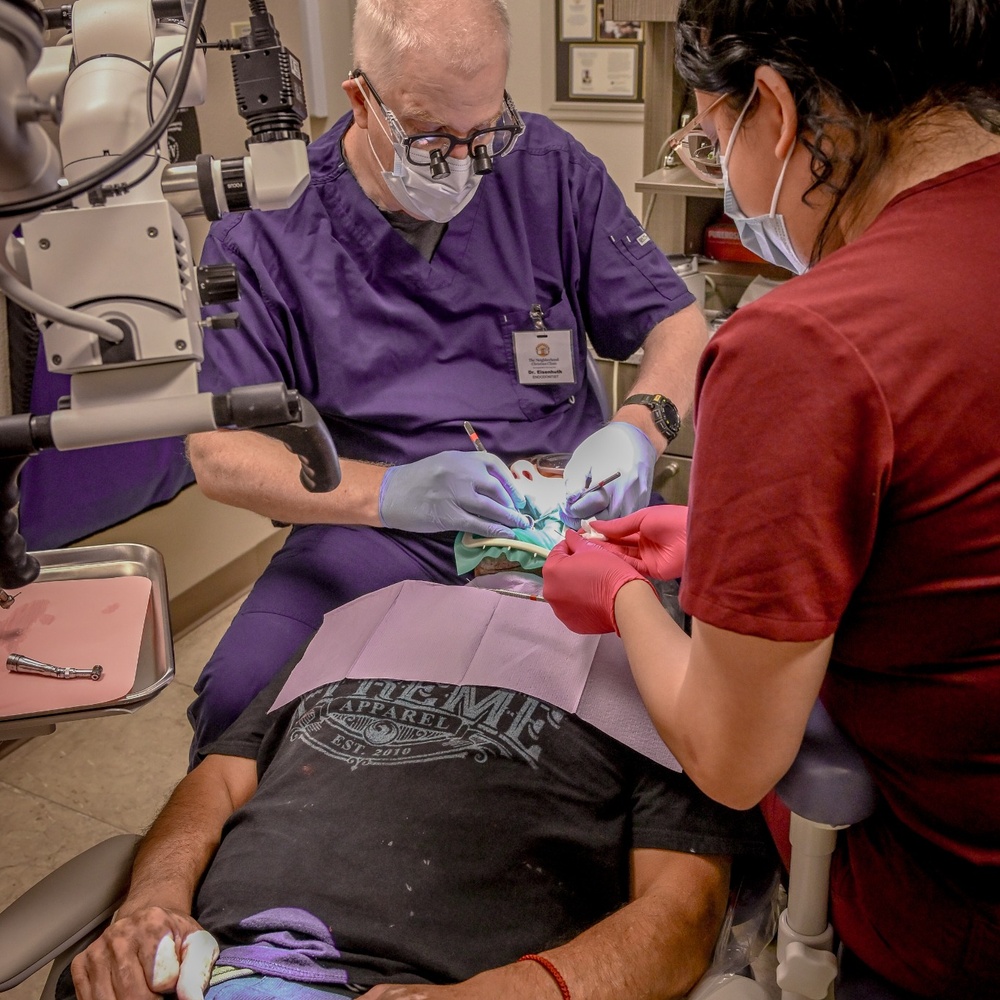 Dr. Glen Eisenhuth, a volunteer dentist at The Neighborhood Christian Clinic, provides dental treatment to a patient.